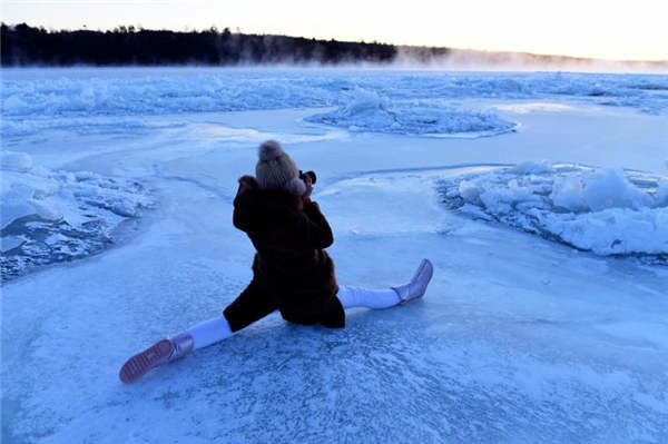 Yoga enthusiasts practice on frozen river in Heilongjiang