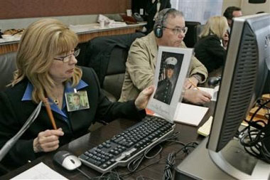 Sally Regenhard, holds a photo of her son Christian, a New York City probationary firefighter who died on Sept. 11, 2001 while her husband Al Regenhard listens to compact discs of emergency calls on that day that were released in New York, Friday March 31, 2006.[AP]