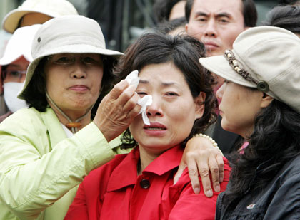 Supporters of South Korean stem cell scientist Hwang Woo-suk weep after hearing the announcement of the result of the prosecutors' investigation into the team led by Hwang, in front of the Seoul district public prosecutors' office May 12, 2006. Hwang, once hailed as a national hero, has been charged with criminal fraud and embezzlement, a senior prosecutor said on Friday. 