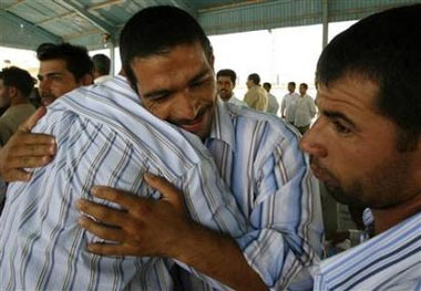 Iraqis embrace each other shortly after they were released from Abu Ghraib prison in Baghdad, June 7, 2006.