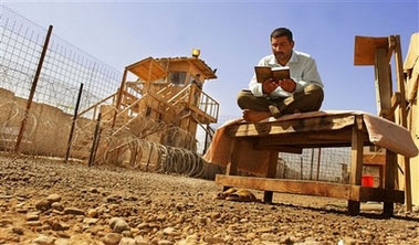 An Iraqi detainee reads the Quran, Islam's holy book, as he waits to be released at Abu Ghraib prison, west of Baghdad in Iraq Sunday, June 11, 2006. Around 230 detainees were released from the four American run prisons of Cropper, Suse, Bucca and Abu Ghraib, after many were taken to Abu Ghraib prison for processing before release. (AP Photo
