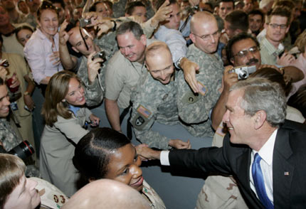 US President George W. Bush (R) greets military personnel and embassy employees at the US Embassy after he arrived in Baghdad for a surprise visit to the city June 13, 2006. [Reuters]