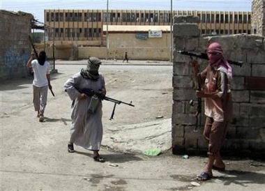 Masked insurgents carry their weapons while patrolling a street in the restive Iraqi city of Ramadi, 60 miles west of Baghdad, May 8, 2006. Insurgents who have killed U.S. troops in Iraq would not be pardoned under the Iraqi government's amnesty plan, American newspapers quoted Prime Minister Nuri al-Maliki as saying on Wednesday. [Reuters]