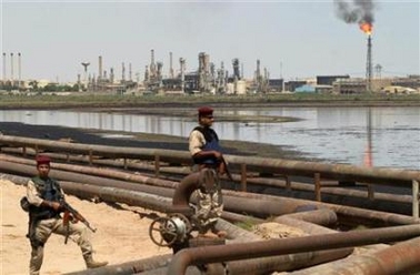 Iraqi border police officers stand guard near the Al-Sheiba oil refinery in the southern Iraq city of Basra, May 24, 2005. The popular refrain in Washington of weaning America off Middle Eastern oil is an unattainable goal that may end up hurting the country in the long run, top oil executives said on Tuesday. [Reuters]