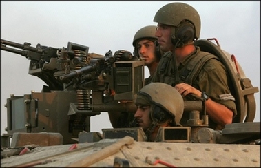 Israeli soldiers sit in an armored personnel carrier (APC) as they cross the Israeli border into the Gaza Strip from the nearby Kibbutz of Zikim. [AFP