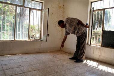Neighbor and eyewitness Hussein Mohammed, 33, points to the blood splattered floor and wall where he found the three killed family members of the young Iraqi girl who was allegedly raped then killed in another room in their home, Thursday, July 6, 2006, in Mahmoudiya, south of Baghdad, Iraq. Former US Army Pfc. Steve D. Green was charged Monday in federal court in Charlotte, North Carolina, with rape and four counts of murder. At least four other U.S. soldiers still in Iraq are under investigation in the attack. (AP Photo