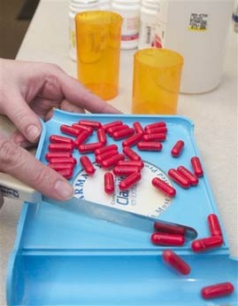 A pharmacy worker counts pills in Omaha, Neb. on Tuesday March 16, 2004. Medication mistakes injure well over 1.5 million Americans every year,the Institute of Medicine said. (AP Photo