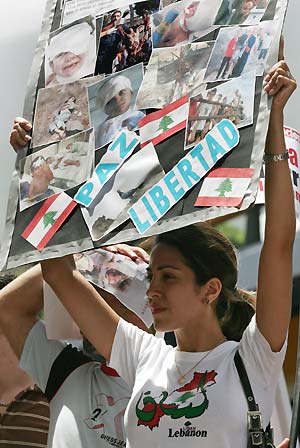 A Lebanese woman holds up a placard featuring pictures of unidentified victims during an anti-Israel protest outside of the Israeli embassy in Caracas July 20, 2006. Hizbollah fought fierce battles with Israeli troops on the Lebanese border on Thursday, as thousands more foreigners fled the nine-day-old war in Lebanon, including 1,000 Americans evacuated by U.S. Marines.