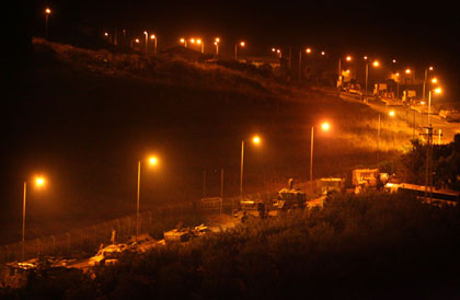 Israeli army vehicles are lined up before going into Lebanon north of Kiryat Shmona, close to the Israel-Lebanon border, early morning July 30, 2006. 