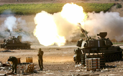 Israeli soldiers stand behind 155mm mobile artillery firing into southern Lebanon, from a position on the Israeli-Lebanese border August 6, 2006. Hizbollah killed 11 Israeli soldiers on Sunday in its deadliest rocket strike yet and Israeli bombs killed 18 Lebanese civilians as Lebanon rejected a draft U.N. resolution to end the 26-day-old war. 