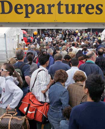 Passengers queue at Terminal Four of Heathrow Airport, near London for delayed flights, August 12, 2006. The British government on Saturday rejected as "dangerous and foolish" accusations that its foreign policy heightened the threat of terror attacks after police foiled a plot to blow up transatlantic airliners. 