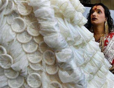 Laxmi Narayan Tripathi, a transvestite from India, looks at a dress made of condoms by Brazilian artist Adriana Bertini at the International AIDS conference in Toronto August 17, 2006.