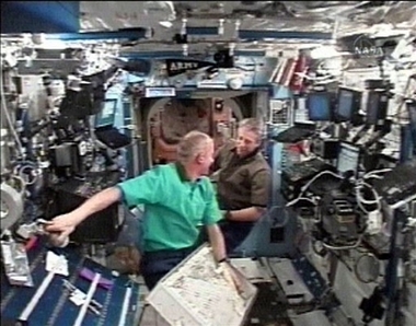 In this image from NASA TV, International Space Station astronaut Jeff Williams, left, and European Space Agency astronaut Thomas Retter of Germany, work in the laboratory of the station, Monday, Sept. 18, 2006.