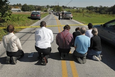 People kneel and pray on White Oak Road, Monday, Oct. 2, 2006, in Nickel Mines, Pa. A milk-truck driver carrying three guns and a childhood grudge stormed a one-room Amish schoolhouse Monday, sent the boys and adults outside, barricaded the doors with two-by-fours, and then opened fire on a dozen girls, killing three people before committing suicide. (AP Photo