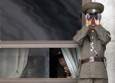 North Korean soldiers observe the south side through binoculars at the truce village of Panmunjom in the demilitarized zone (DMZ) that separates the two Koreas since the Korean War, on Wednesday, Nov. 1, 2006. North Korea affirmed Wednesday it would return to nuclear disarmament talks to seek a resolution of a U.S. campaign aimed at choking the communist nation's access to foreign banks. (AP Photo/ Lee Jin-man)