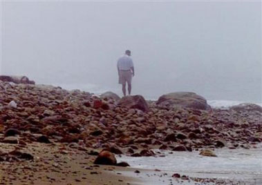 A man walks in heavy fog on a beach in a file photo. A gene associated with depression and other forms of mental illness may enlarge an area of the brain that handles negative emotions, U.S. researchers reported on Wednesday.