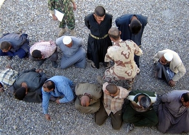 Iraqi soldiers guards detainees in Baqouba, 60 kilometers (35 miles) northeast of Baghdad, Iraq, Wednesday, Nov. 8, 2006. Iraqi military killed three suspected militants and detained 13 others in a raid. (AP 