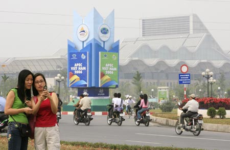 Women take photos in front of the venue for the upcoming Asia-Pacific Economic Cooperation (APEC) meeting in Hanoi November 12, 2006. 