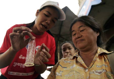 A volunteer demonstrates how to use a condom at a beauty salon in Phnom Penh market on World Aids day December 1, 2006. Cambodia has the highest prevalence of HIV/AIDS in Asia, with 1.9 percent of the population, or approximately 123,000 people, infected, while the highest number of new HIV infections -about 40 percent- occur in married women in the impoverished country, according to the United Nations and government statistics.