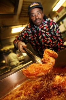 H. Kenneth Woods, chef and owner of Sylvia's restaurant, cooks southern fried chicken using a soy bean oil that doesn't contain trans fats in this Friday, Sept. 29, 2006 file in New York's Harlem neighborhood.