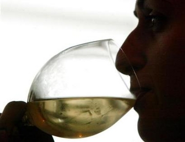 A customer tastes a wine in a wine shop in Tbilisi, March 28, 2006. Moderate drinking may lengthen your life, while too much may shorten it, researchers from Italy report. Their conclusion is based on pooled data from 34 large studies involving more than one million people and 94,000 deaths.