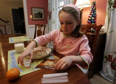 Elizabeth White, 7, mixes peanut powder with a fruit roll-up before taking her daily dosage in Raleigh, N.C., Thursday, Dec. 21, 2006. A study at Duke University is trying to help children with peanut allergies tolerate at least a little exposure. (AP