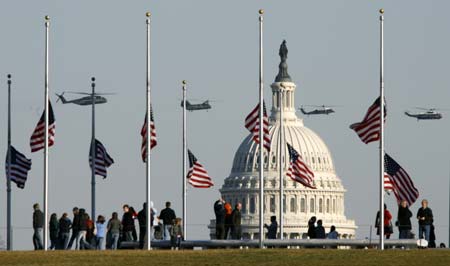 Flags fly at half staff in memory of former U.S. President Gerald Ford at the Washington Monument as military helicopters pass over the dome of the Capitol in Washington December 27, 2006. Ford, the 38th U.S. President, died at his home in California on Tuesday at age 93. Ford's body will lie in state for a period of public mourning in the Capitol Rotunda beginning this weekend. 