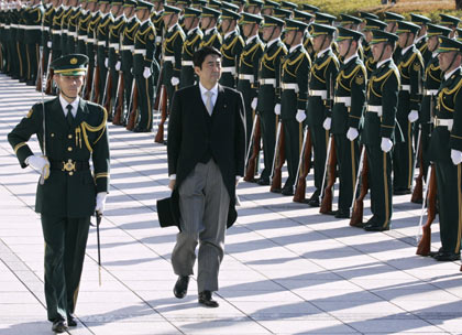 Japanese Prime Minister Shinzo Abe (C) reviews troops during a ceremony marking the Defence Agency being upgraded to a ministry, at Defence Ministry in Tokyo January 9, 2007. [Reuters]