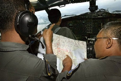 Indonesian air force officers look over a chart during a search for a missing Boeing 737 carrying 102 people over the Makassar Strait in Indonesia Wednesday, Jan. 10, 2007. In addition to aerial search, a U.S. Navy oceanographic survey ship was trying to determine Wednesday if metal objects found off Sulawesi Island's western coast were the wreckage of a Boeing 737 that disappeared more than a week ago carrying 102 people. (AP Photo