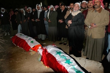 People pray beside the coffins of Barzan Ibrahim, Saddam's half brother and former intelligence chief, and Awad Hamed al-Bandar, former head of Iraq's Revolutionary Court who were executed at dawn Monday in Baghdad, in the town of Ouja, 115 kilometers (70 miles) north of Baghdad, Iraq, Monday Jan. 15, 2007. (AP