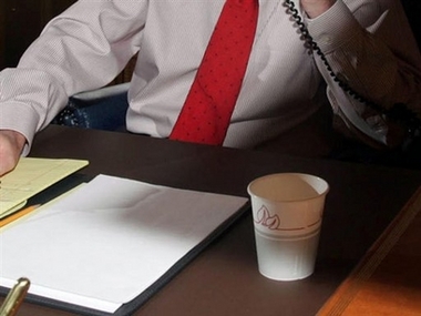 A worker is shown sitting behind his desk at an office. A new research report shows your office desk harbors far more bacteria than your workplace restroom, and if you're a woman, chances are your workspace has more germs than your male co-workers. (AP