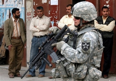 Iraqis watch as a U.S. army 2nd Infantry Division soldier patrols central Baghdad, Iraq, Thursday, March 1, 2007