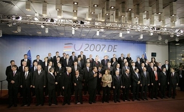 German Chancellor Angela Merkel, center right, speaks with French President Jacques Chirac, center left, during a group photo at an EU summit in Brussels, Thursday March 8, 2007.