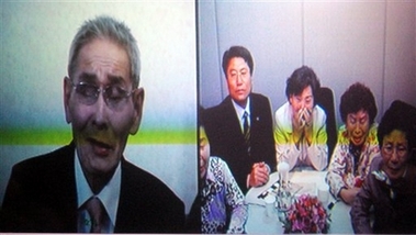 A screen shows a North Korean father Kim Hae Dong, 78, left, talking to his South Korean daughter Kim Ki-jo, center, and his South Korean relatives, right, through video during a video family reunion session at the video conferencing room of Red Cross in Busan, south of Seoul, South Korea, Tuesday, March 27, 2007. South and North Korea on Tuesday held a new round of three days family reunions via video link after a 13-month hiatus. (AP