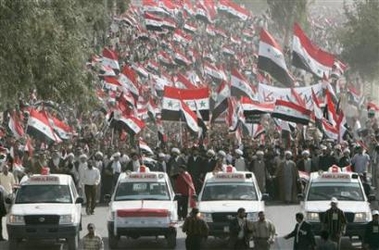 Demonstrators wave Iraqi flags as they march during a rally marking four years to the day since Baghdad fell to invading American troops, in Najaf, south of Baghdad, April 9, 2007.