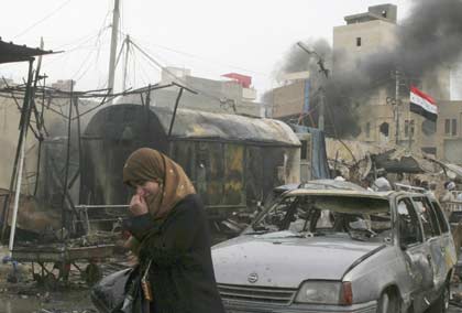 A woman walks near the scene of a car bomb attack in Kerbala, 110 km (70 miles) south of Baghdad April 14, 2007. A suicide car bomber killed at least 40 people and wounded 128 at a crowded bus station near a major Shi'ite shrine in the Iraqi holy city of Kerbala on Saturday, police and hospital sources said. REUTERS/