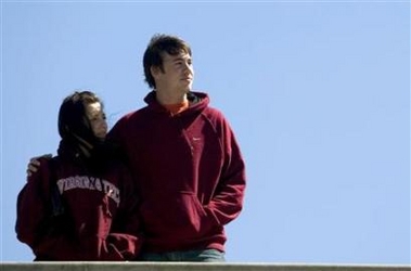 Virginia Tech students stand arm in arm as they overlook a memorial on the university's campus in Blacksburg, Virginia, April 17, 2007.