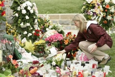 A Virginia Tech faculty member lays a flower at a memorial to the victims of the Virginia Tech shooting, on the campus in Blacksburg, Virginia April 19, 2007.