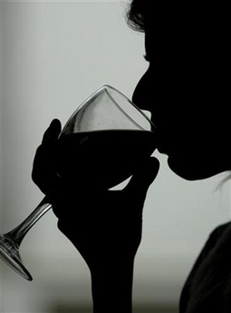 A woman tastes red wine at a bar in central Athens March 30, 2004.