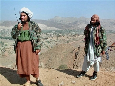 Abdullah Mehsud, left, a former Guantanamo Bay prisoner, talks on his walky-talkie as his body guard looks on near Chagmalai in South Waziristan along Afghanistan border in this Oct 14, 2004 file photo.