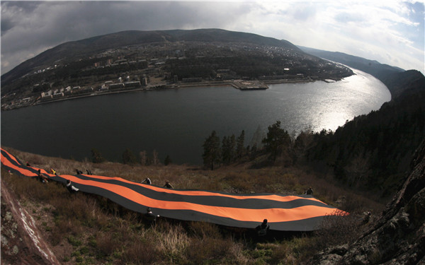 People mark upcoming Victory Day by placing giant St. George's Ribbon