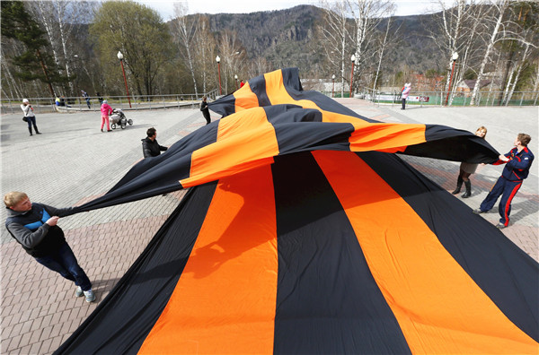 People mark upcoming Victory Day by placing giant St. George's Ribbon