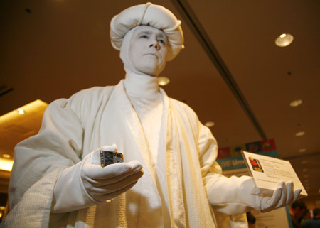 A mime artist stands frozen holding a Sandisk Vaulter Disk at the Consumer Electronics Show CES Unveiled event in Las Vegas, Nevada Jan. 5, 2008. The disk is a flash-based module for high-capacity laptops and won a Best of Innovations 2008 award. The show opens January 7.(Xinhua/Reuters Photo)