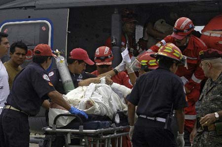Rescue workers transport a survivor of a plane crash at an Air Force base in Guatemala City, Sunday, Aug. 24, 2008. A small plane crashed in a field in eastern Guatemala on Sunday, killing 10 people, including five Americans, aviation and army officials said.
