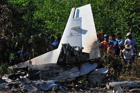 Villagers stand at the site where a plane crashed in Cabanas village, Guatemala, Sunday, Aug. 24, 2008. A small plane crashed in a field in eastern Guatemala on Sunday, killing 10 people, including five Americans, according to an aviation official and a survivor.