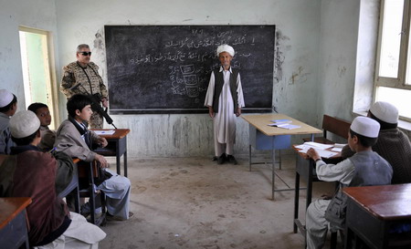Afghan school continues as soldiers guard aside