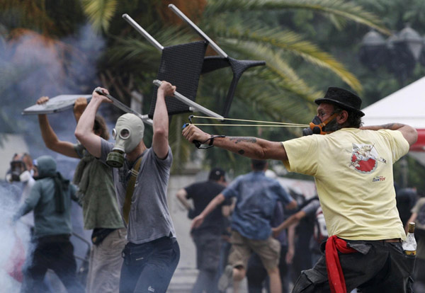 Greece passes steep cuts as riots seize capital