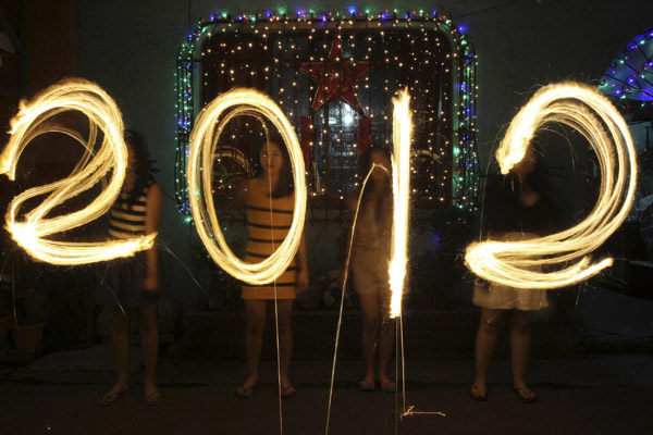 World rings in 2012 and bids adieu to a tough year