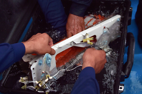 Divers retrieve AirAsia 'black box', explosion theory questioned