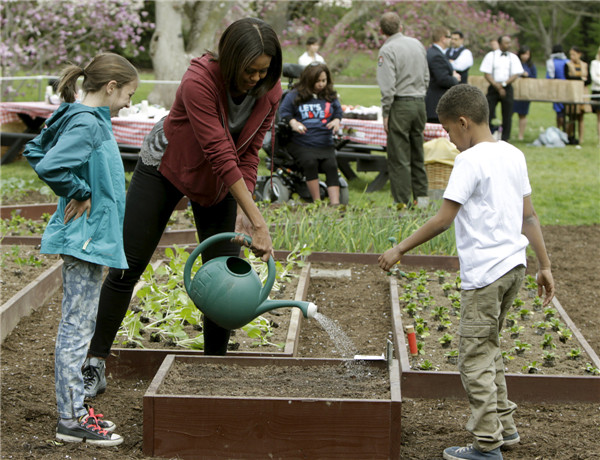 Michelle Obama plants vegetables with school children